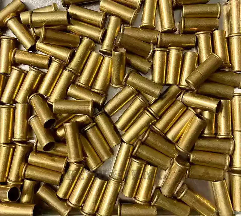 The image shows a collection of 22 rimfire bullet casings, showcasing their small cylindrical shapes and varying golden metallic hues. These casings, once used for ammunition, now find a new purpose in arts and crafts projects. They can be repurposed to add a touch of rugged charm to jewelry, mixed media art, or other creative endeavors, offering both aesthetic appeal and eco-consciousness.